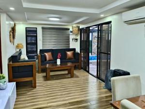 a living room with a blue couch and a table at YBonita in Sampong