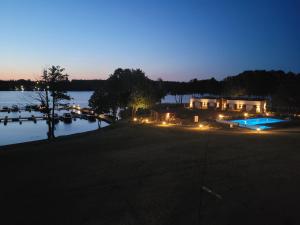 a night view of a house and a lake at Apartament Kocia Wyspa in Węgorzewo