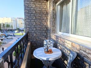 a small table on a balcony with a window at Cool Family Apartment 2Chambres Balcon,WiFi,Tanger in Tangier