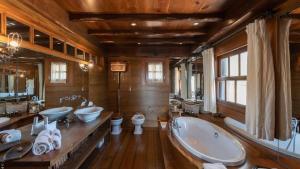 a large bathroom with three sinks and a bath tub at Unique Villa Offering Vast Spaces in Toiny