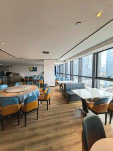 una sala da pranzo con tavoli, sedie e finestre di Changsha Feiji Hotel a Changsha