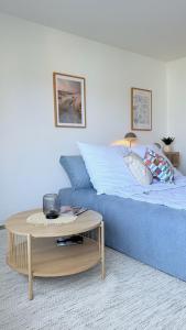 a bedroom with a blue bed and a table at Sonnenbalkon, strandnah & gemütlich - ideal für 2-3 Personen - Family & Friends HYGGE Ferienwohnung in Grömitz +12 photos