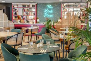 a restaurant with tables and chairs and a chalkboard at Appart'City Collection Paris Roissy CDG Airport in Roissy-en-France