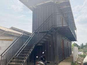 a staircase leading to a building with a motorcycle parked outside at RedDoorz Syariah at Budget Guesthouse Sepaku in Sepaku +8 photos