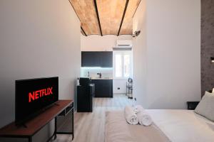 un salon avec un lit et une télévision dans l'établissement Circo Massimo Suite - In the heart of Testaccio, à Rome 9 autres photos