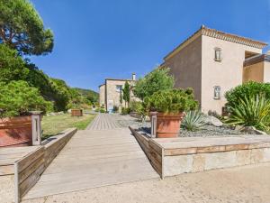 a wooden walkway with potted plants in front of a building at Résidence Aigue Marine in Coti-Chiavari