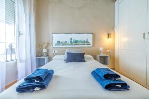 une chambre avec un lit avec deux serviettes bleues dessus dans l'établissement Aromas de Especieros, à Cordoue