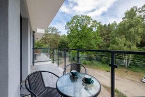 Una mesa y sillas en un balcón con vista. en Nadmorski Apartament w Pobierowie z Parkingiem oraz Basenem by Noclegi Renters, en Pobierowo 22 fotos más