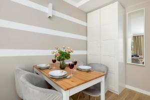 Un comedor con mesa y sillas de madera. en Nadmorski Apartament w Pobierowie z Parkingiem oraz Basenem by Noclegi Renters, en Pobierowo