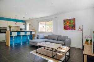 a living room with a couch and a table at Les Embruns d Arcachon - Villa avec Piscine Chauffée in Arcachon