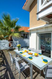 a white table with chairs and food on it at Les Embruns d Arcachon - Villa avec Piscine Chauffée in Arcachon