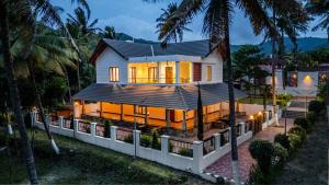 a house with lights on the front of it at Senaro Farms in Varagampadi