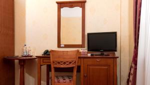 a room with a desk with a television and a chair at Pokoje Korona Bed & Breakfast in Sandomierz