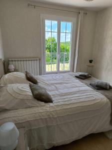 a large bed in a bedroom with a large window at la maison de Gaston in Rix