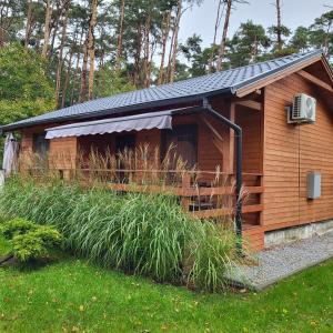 a small wooden cabin with a roof at MARWIKOWE Domki Wypoczynkowe in Sieraków +22 photos