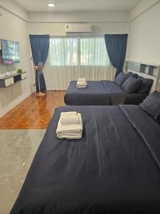 un dormitorio con dos camas y un sofá en Middletown chiangmai 2king bed, en Chiang Mai