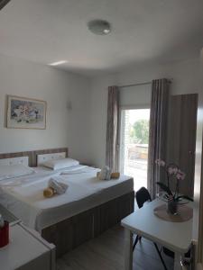 a hotel room with two beds and a window at VILA MOZAIK in Kavajë