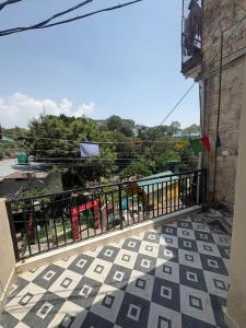 a balcony with a fence and a view of a city at Rudra Home stay l On heritage Market kasauli l Best food Cafe Rudra l Kasauli in Kasauli +5 photos