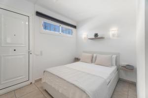 Un dormitorio blanco con una cama y una ventana. en Greta Costa del Silencio, en Costa del Silencio 16 fotos más