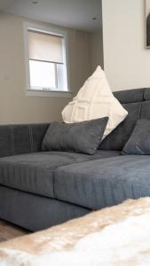 a gray couch in a living room with a window at Graham House in Livingston