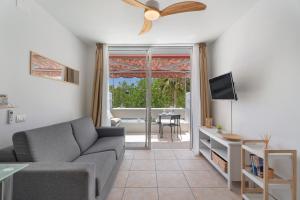Una sala de estar con un sofá y un televisor. en Greta Costa del Silencio, en Costa del Silencio