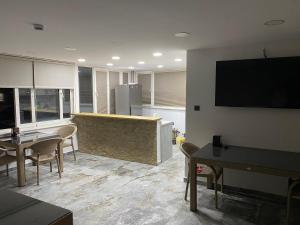 a living room with tables and chairs and a television at Uyar Pansiyon & Apart in Bodrum City