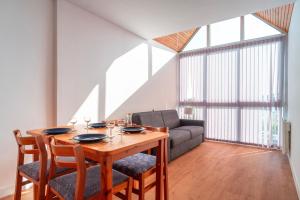 a dining room with a table and a couch at Cap Trinité - Studio avec parking proche port in La Trinité-sur-Mer