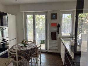 een keuken met een tafel met een kom bloemen erop bij Maison du F'Or in Huningue