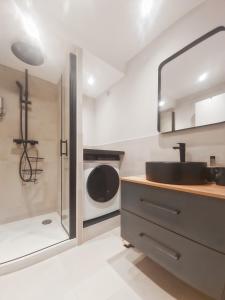 une salle de bain avec un lavabo et une machine à laver dans l'établissement Appartement cosy lumineux avec balcon, à Nice