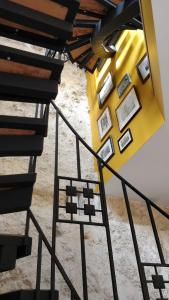 a staircase with a yellow wall with pictures on it at La maison de Madeleine in Rochecorbon