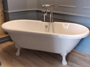 a white bath tub with a faucet in a bathroom at La maison de Madeleine in Rochecorbon +10 photos