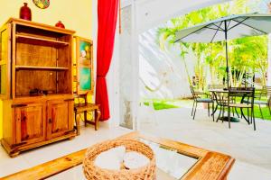 a living room with a table and an umbrella at Playacar - Executive Budget Room With Swimming Pool Air Conditioning and Parking in Playa del Carmen