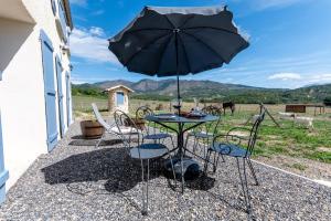 un tavolo e sedie con un ombrellone in un patio di Plaines-Provence Spa&Sauna a Digne-Les-Bains