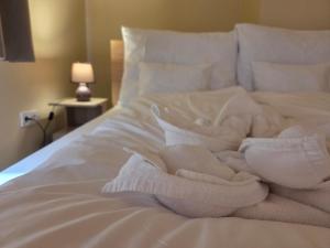 Una cama blanca con toallas blancas. en Downtown Apartman - Friends, en Győr 8 fotos más