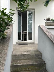 een open deur van een wit huis met trap bij Maison du F'Or in Huningue