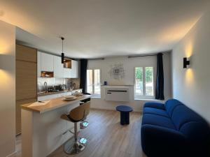 普罗旺斯艾克斯Le Nid des Cardeurs studio cosy centre historique的带蓝色沙发的客厅和厨房