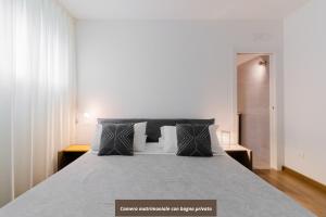 sypialnia z dużym łóżkiem i białymi ścianami w obiekcie Suite Rosso & Nero - Lecce Selection w mieście Lecce