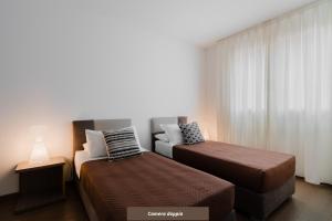 sypialnia z dwoma łóżkami i oknem w obiekcie Suite Rosso & Nero - Lecce Selection w mieście Lecce