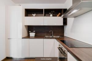 kuchnia z białymi szafkami i zlewem w obiekcie Suite Rosso & Nero - Lecce Selection w mieście Lecce