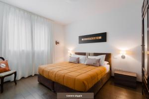sypialnia z łóżkiem z pomarańczowym kocem w obiekcie Suite Rosso & Nero - Lecce Selection w mieście Lecce