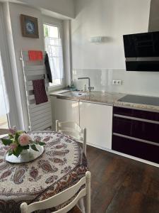 een keuken met een tafel met een bloem erop bij Maison du F'Or in Huningue