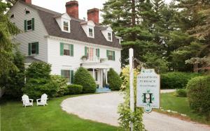 a white house with a sign in front of it at Hampton Terrace Inn in Lenox