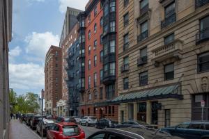 a city street with cars parked next to tall buildings at Walk to Boston Common, Central Stay in Boston