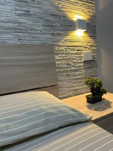a bedroom with a bed and a stone wall at CAMARDA SUITE in Bernalda