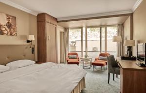 ein Hotelzimmer mit Bett, Schreibtisch und Stühlen in der Unterkunft Hotel Ullensvang in Lofthus