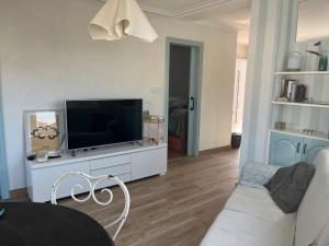 una sala de estar con TV de pantalla plana en un armario blanco en Apartamento en playa América, en Nigrán