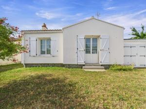 a white house with a garage at Maison pour 6 avec jardin proche du centre in Saint-Gilles-Croix-de-Vie