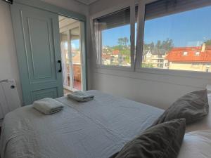 un dormitorio con una cama con dos almohadas. en Apartamento en playa América, en Nigrán