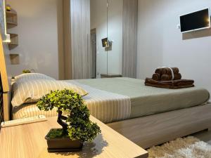 a bedroom with a bed and a potted plant on a table at CAMARDA SUITE in Bernalda