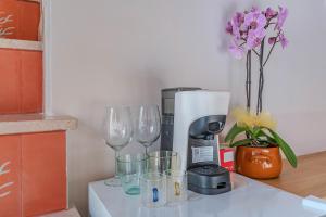 a counter with wine glasses and a coffee maker at AMar in Polignano a Mare +13 photos